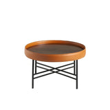 Mesa de café redonda de nogal natural con tapicería de piel de vaca cognac Angel Cerdá