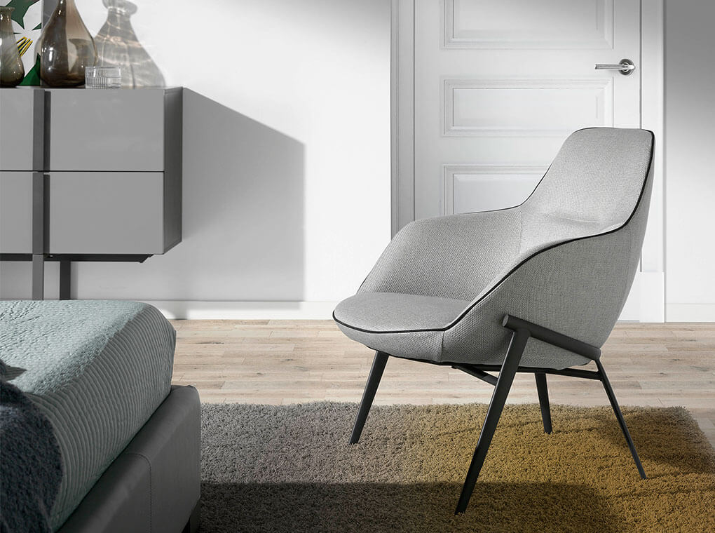 Sillón tapizado en tela gris y estructura de acero negro Angel Cerdá